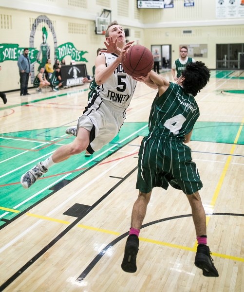 Holy Trinity Academy Knight Ethan Miller defies gravity and sails over Springbank Phoenix guard Karim Davarani on Jan. 13 at the 20th annual Knights Classic. The Knights took 