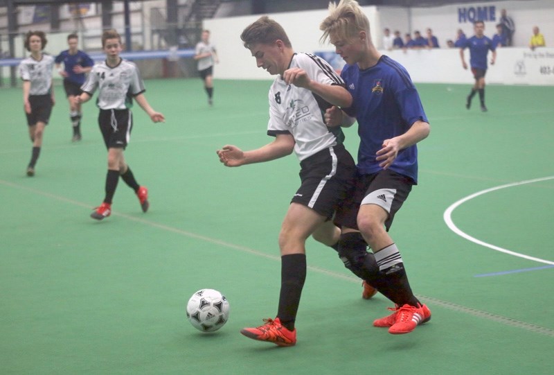 Okotoks United Josh Hodgkins keeps possession away from an Airdrie FC defender during the U16 Tier II gold medal game of the United Communities Cup on Jan. 29.