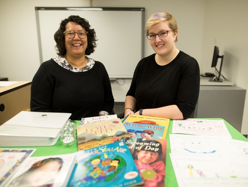 Roots of Empathy educator Deborah Payne and program director Sarah Wood with program materials on Feb. 4.