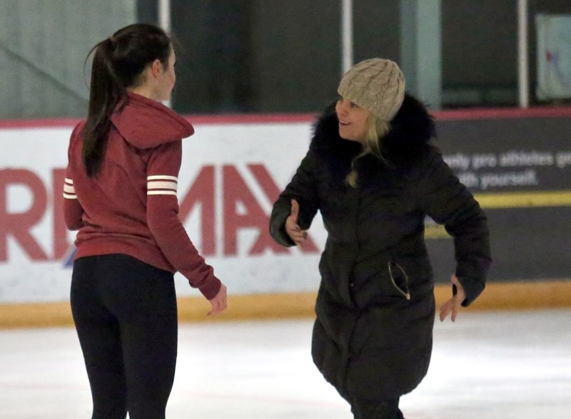 Okotoks Figure Skating coach Kerri Roberts, in bonnet, gives some tips to Elix Waldner at the Piper Arena Jan. 27. Roberts recently earned her Level 4 certification, allowing 