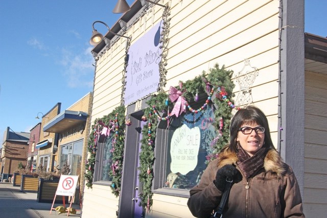 Bali Bling Gift Store employee Jennifer Hulburd stands in front of the store after it was struck by a semi-trailer last month, cracking the support beam on the right.