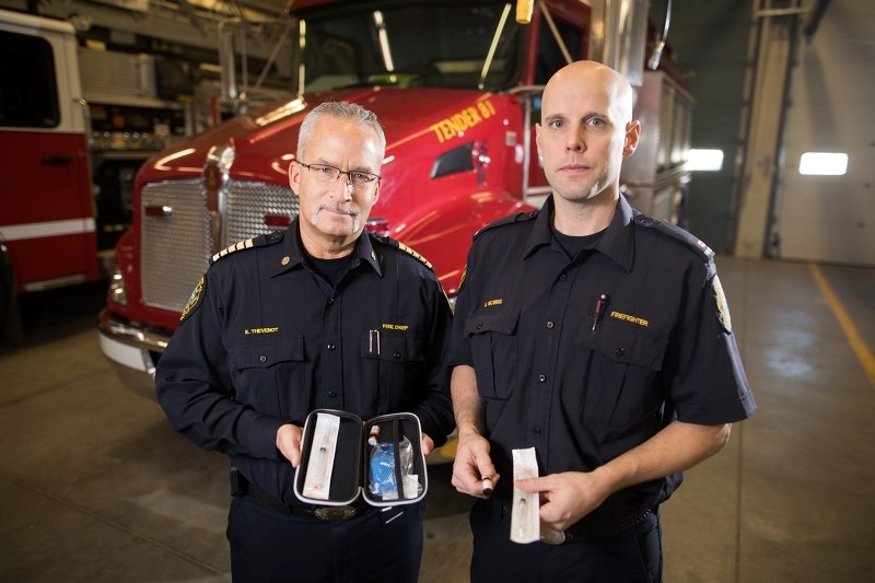 Okotoks Fire Chief Ken Thevenot and firefighter Adam McInnis with a Naloxone kit on Feb. 14.