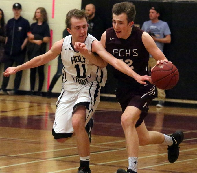 Holy Trinity Knight Cole Fieseler defends the dribbling Foothills Falcon Adam Pahl on Feb. 17.