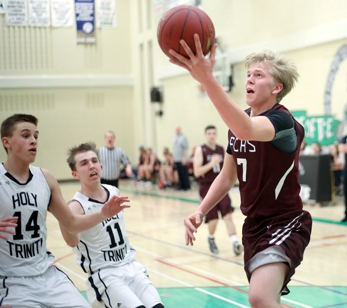 Foothills Falcon Peter Baker drives to the basketball while Holy Trinity Academy Knight Justin Cyr (14) defends March 9 at Holy Trinity Academy.
