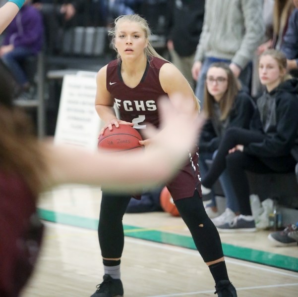 Foothills Falcon Hannah Helton looks for an open teammate in their 66-36 win over the Holy Trinity Academy Knights in the 4A South Central zone final March 9 at HTA.