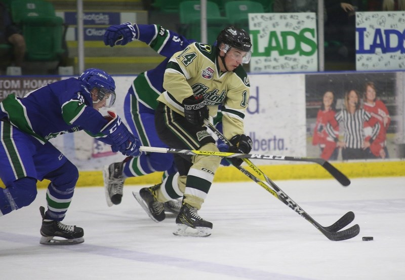 Okotoks Oilers forward Kyle Gordon fends off a pair of Calgary Canucks during the team&#8217;s 5-1 win in Game 3 of the South semifinal, March 20 at Pason Centennial Arena.