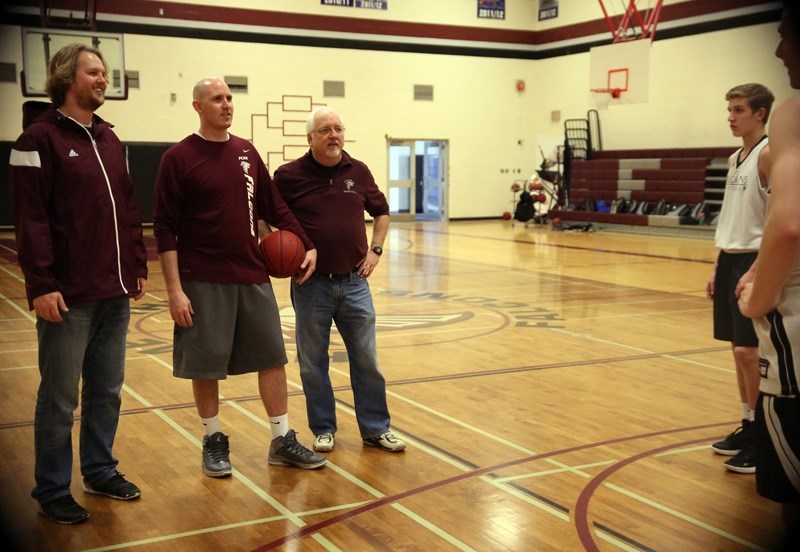 Foothills Falcon basketball coaches, from left, Brady Byam, head coach Amron Gwilliam and Steve Lloyd share a laugh with players before their March 15 practice.