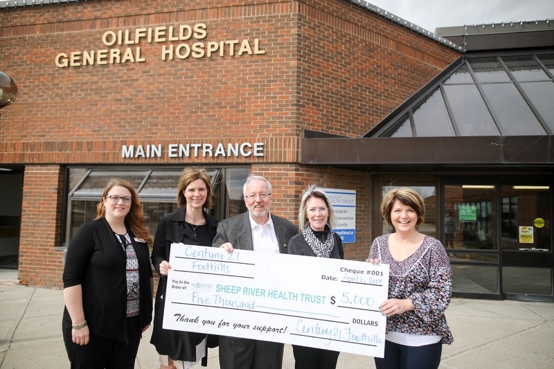 Officials with the Sheep River Health Trust receive a $5,000 cheque from Century 21 Foothills to kick off a fundraising supporting Foothills health and wellness initiatives