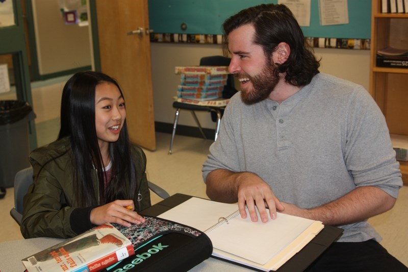 Drew Hoover, a teacher at High River&#8217; s Senator Riley Middle School, goes over an upcoming lesson with Christine Lim. Hoover, a 2008 Foothills Composite grad, is the