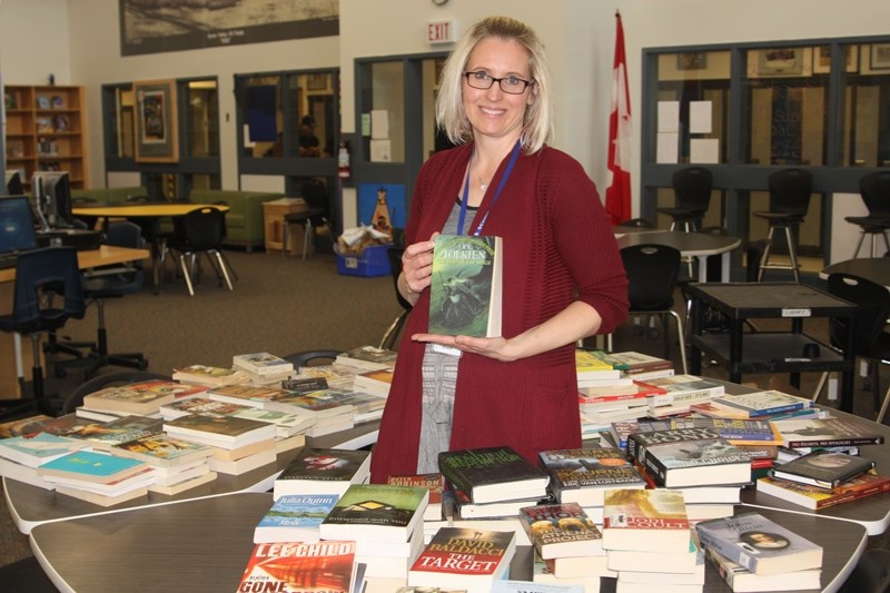 Oilfields High School librarian Cindy Watts surrounds herself with just a few of the 5,000 books that will be on April 26-27.