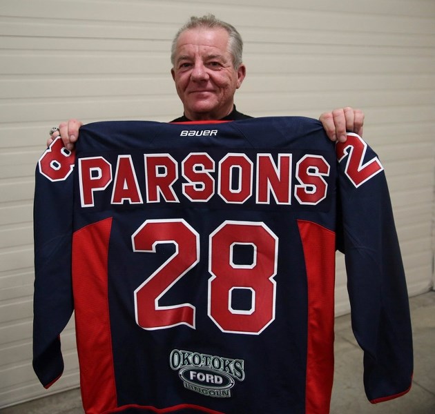 Okotoks Bisons president Mike Parsons holds a jersey presented to him for 28 years of service to the club at the team&#8217;s 2017 awards banquet on April 21 at the Foothills 