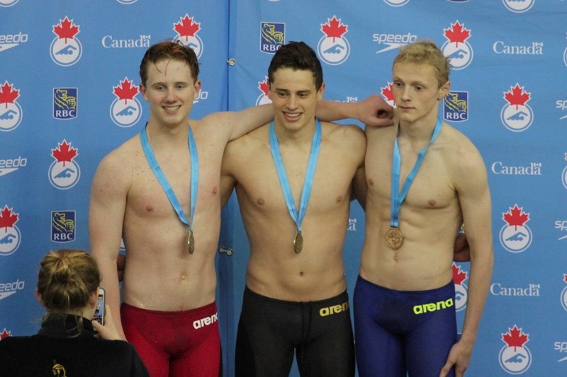 DeWinton&#8217;s Justin Lisoway poses on the top of the podium after winning a gold medal in the 100m backstroke at the Speedo Western Championships at the Repsol Sports