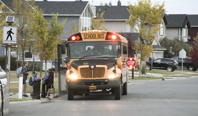 A Southland Transportation school bus loads students heading to Brant Christian School on Cimarron Drive early in the morning on Sept. 26.