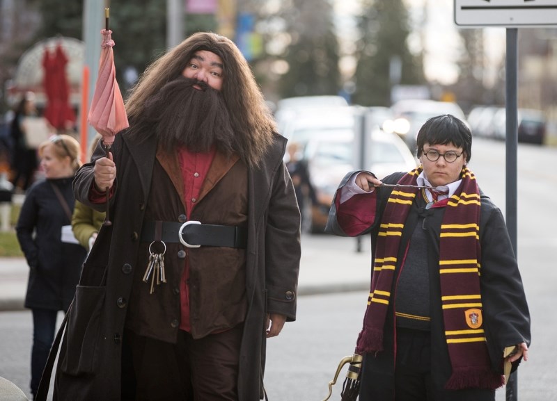 Emil and Skylar Starlight stroll down North Railway St. as Hagrid and Harry Potter during the Wizarding World of Okotoks on Oct. 28. The event, organized by the Okotoks Arts