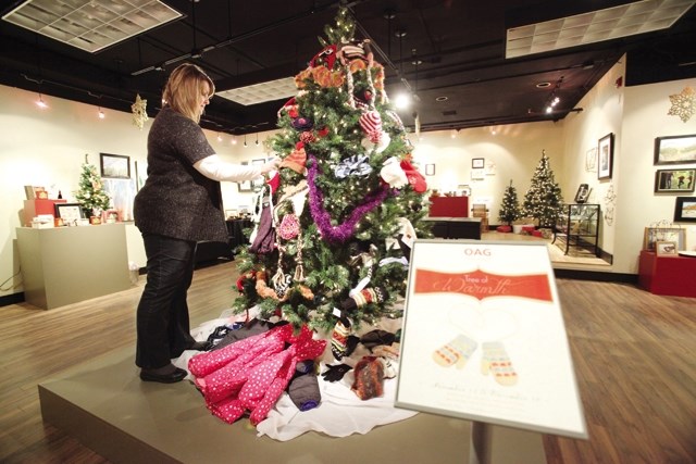 Andrea Spiers, visitor services specialist, admires the Tree of Warmth in the Okotoks Art Gallery in a previous year. Gallery staff are asking for donations of new scarves,