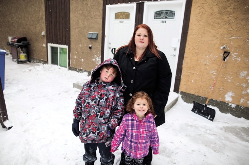 Amy Lee Goodison with her children Oliver and Sofie in front of their residence in Okotoks on Nov. 3. Goodison is speaking out against what she calls unfair treatment by