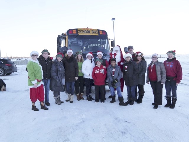 Santa and elves aboard the Magic of Christmas bus get ready to hand out gifts and spread holiday cheer.