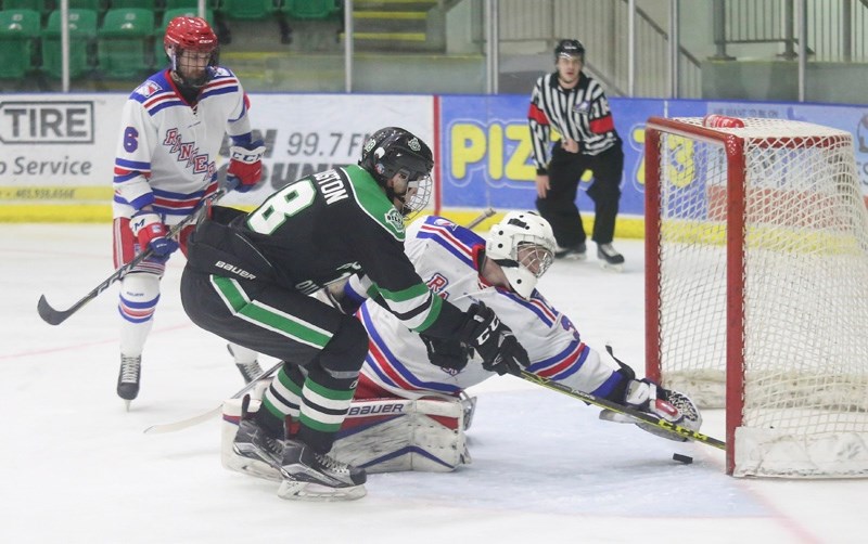 Okotoks Bow Mark Oilers forward Kale Clouston tries to get his stick on the puck as Fort Saskatchewan Rangers netminder graps for it on the line during Okotoks&#8217; 2-1 win 