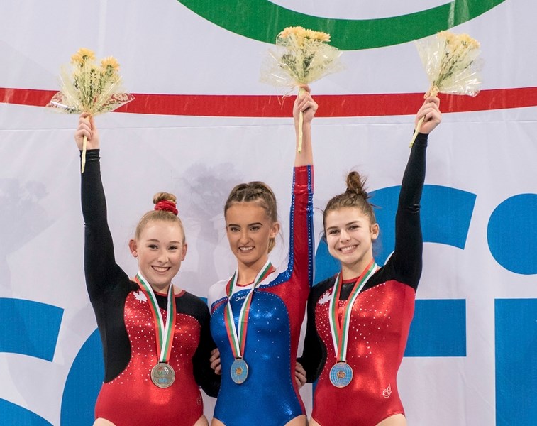 Okotokian Mackenzie Kyfiuk, left, stands on the podium after capturing the silver medal in double-mini trampoline at the Gymnastics Trampoline World Age Group Competition in