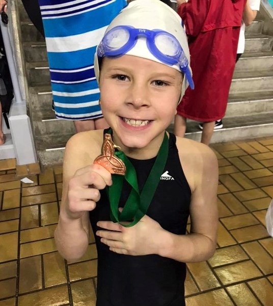 Foothills Stingray Hailey Thiele proudly shows one of her bronze medals from the Killarney Invitational meet.