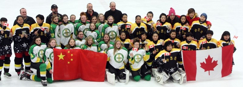 The Okotoks Peewee A Oilers and the Harbin, China squad share a moment after their exhibition game Nov. 23 at the Father David Bauer Arena in Calgary.