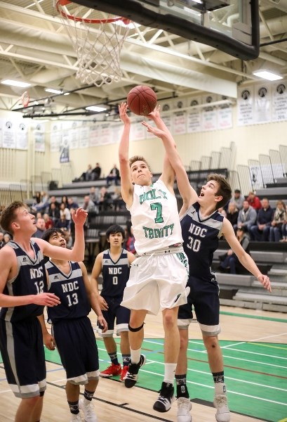 Holy Trinity Academy Knight Matt Scharien goes to the hoop against the Notre Dame Collegiate T&#8217; Wolves Dec. 6 at HTA.