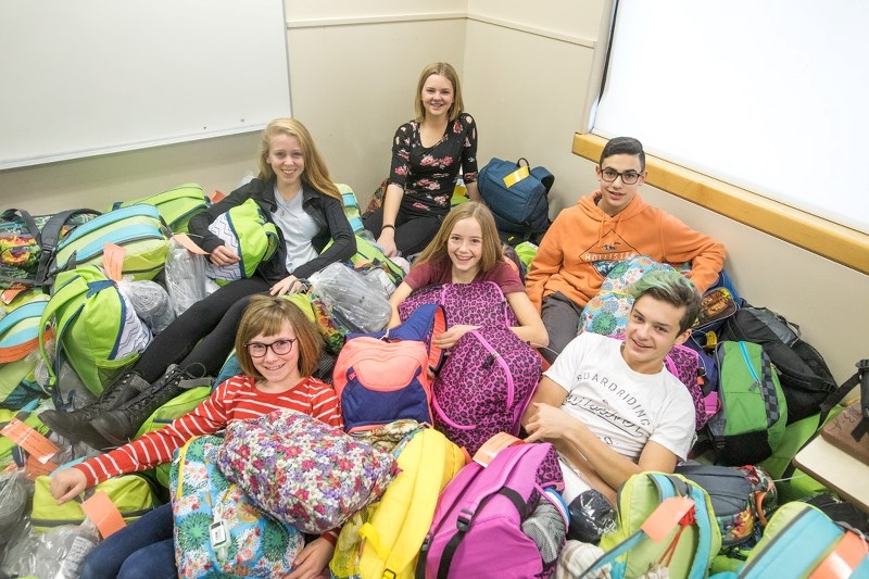 Georgia Carter, Emma Davis, Adrian Pacione, and (front row, L-R) Halla Grunow, Mia Marsh, and Sawyer Quinlan were among students who packed 500 backpacks to be distributed to 