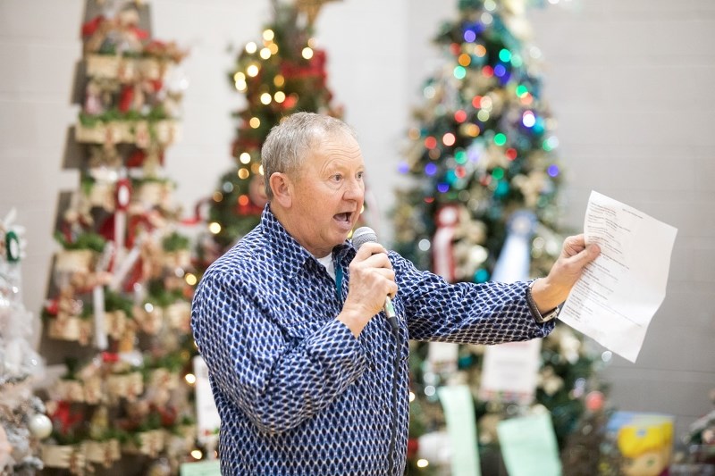 Dave Smith of Couey Auction takes a bid on a tree at the Sheep River Health Trust&#8217; s Avenue of Trees on Dec. 9.