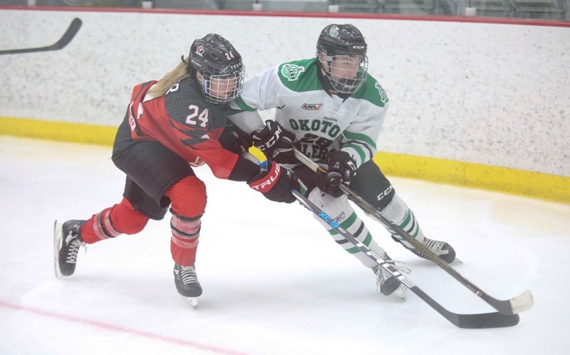 Okotoks Bow Mark Oilers forward Alaister Standen gets tied up with Team Canada winger Natalie Spooner during exhibition action between the teams on Nov. 30. The rematch is