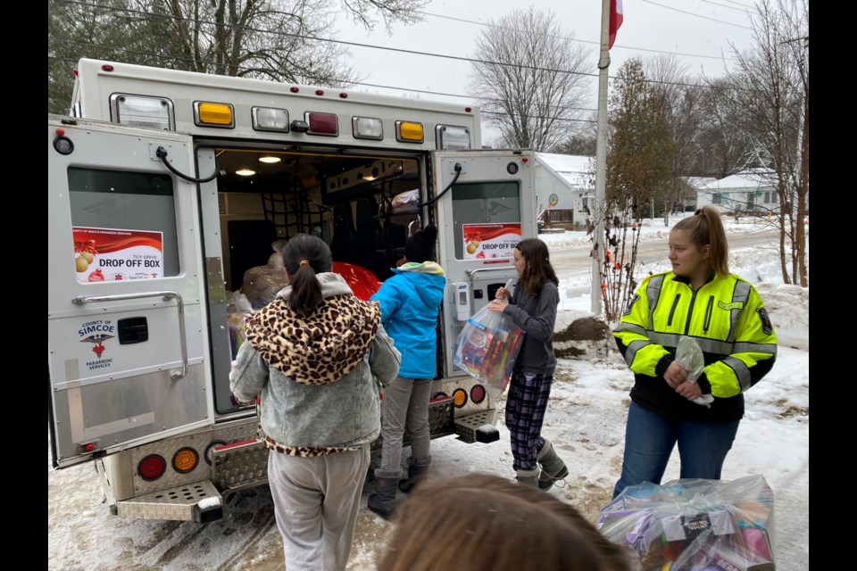 Coldwater Public School students help load toy donations into an ambulance.