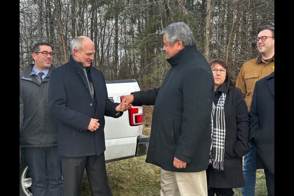 Rama First Nation Chief Ted Williams presents Ramara Township Mayor Basil Clarke with a toonie in exchange for five roads that are now owned by Rama. 