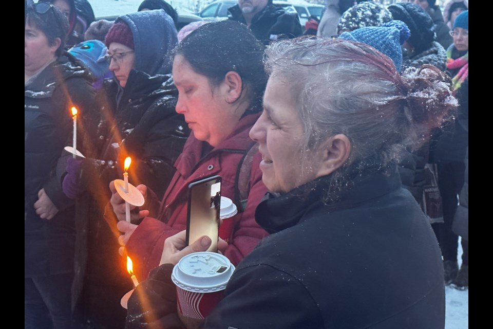 Teary-eyed community members watch on during Monday’s candlelight vigil. 
