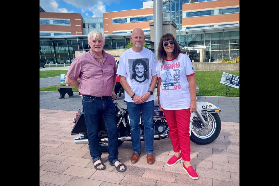 Retired OPP officers Carl Eggiman, left, and Mary Hardisty are shown with Terry Fox’s big brother, Fred Fox, at OPP General Headquarters Wednesday afternoon.