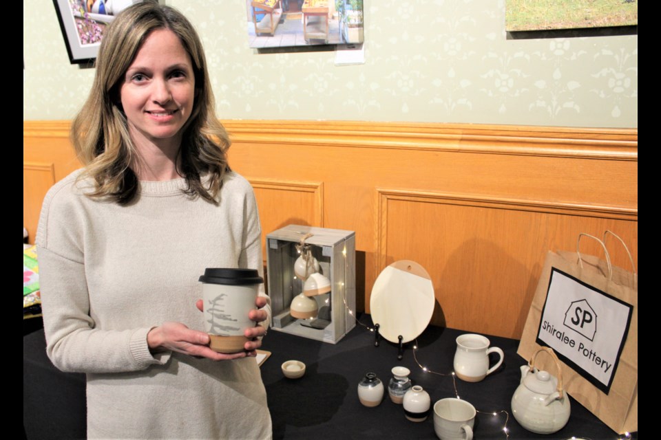 Danielle Skentzos, owner of Shiralee Pottery, shows off one of her travel mugs Thursday during the Artrepreneur Expo at the Orillia Opera House. Nathan Taylor/OrilliaMatters