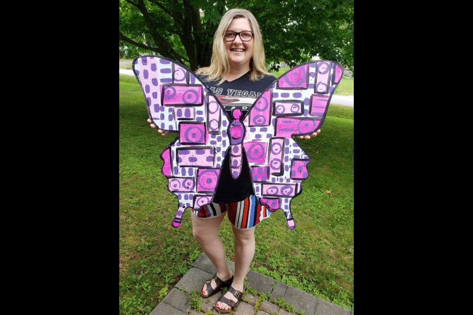 Laura Hinsberger poses with the butterfly she painted that will be among the 100 works of art as part of this year's revamped Streets Alive festival. Contributed photo