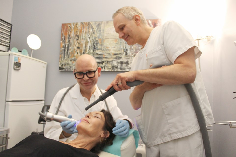 Linda Longauer receives a treatment from Blade Tiessen, left, and Ben Tiessen at their Anti-Aging Clinic in downtown Orillia. Nathan Taylor/OrilliaMatters