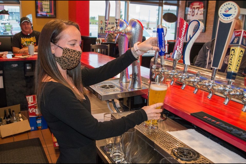 St. Louis Bar and Grill owner Brad Watters watches part-owner Shelby Tanzer pour a pint for a customer. Tyler Evans/OrilliaMatters File Photo