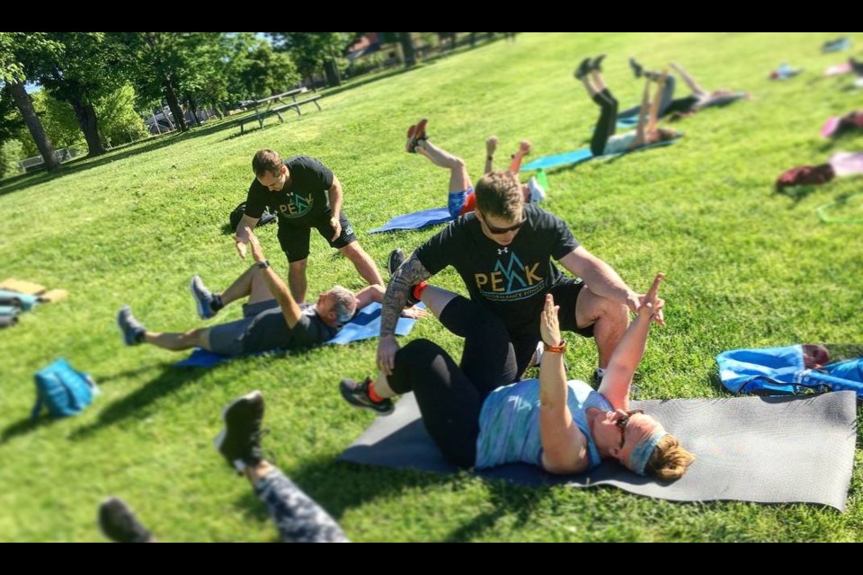 Brandon Peacock provides tips to a person doing yoga at the park this summer. Peacock started Peak Performance and has grown the local business with the help of the CDC. Contributed photo