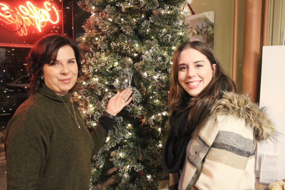 Susan Peacock and her daughter, Kelsey, placed a dove ornament on the Angel Tree at Mariposa Market on Friday in memory of the late Jeff Peacock. Nathan Taylor/OrilliaMatters
