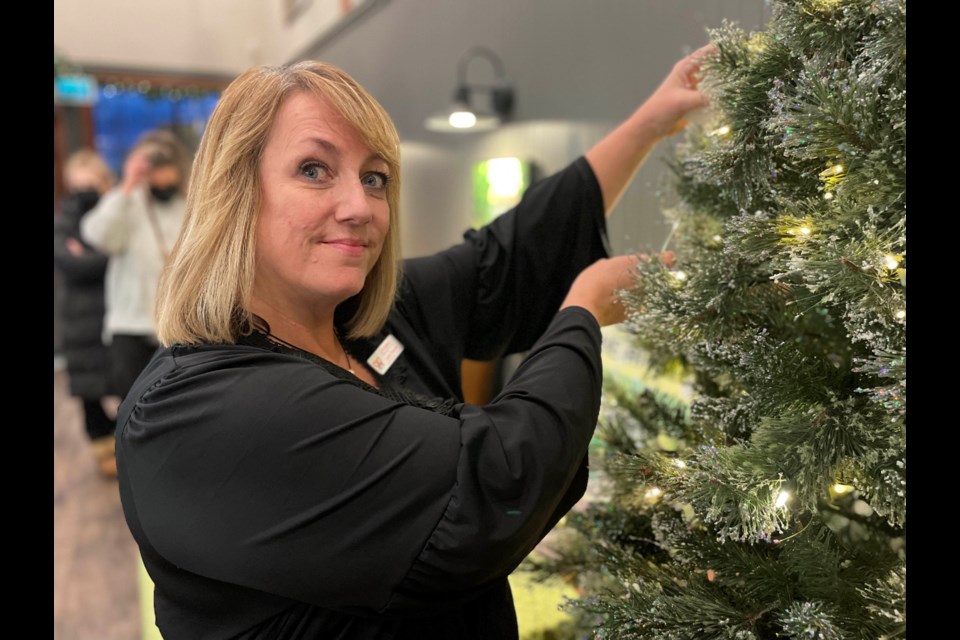 Lynn Thomas, the donor relations coordinator for Mariposa House Hospice, places an angel on the tree to help kick off this year's Angel Tree campaign at Mariposa Market.