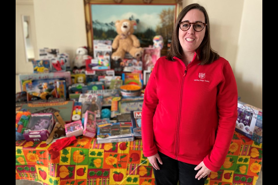Tina Howard, of the Salvation Army in Orillia, stands in front of the collection of toys donated by The Intelligent Elders Club on Saturday afternoon.