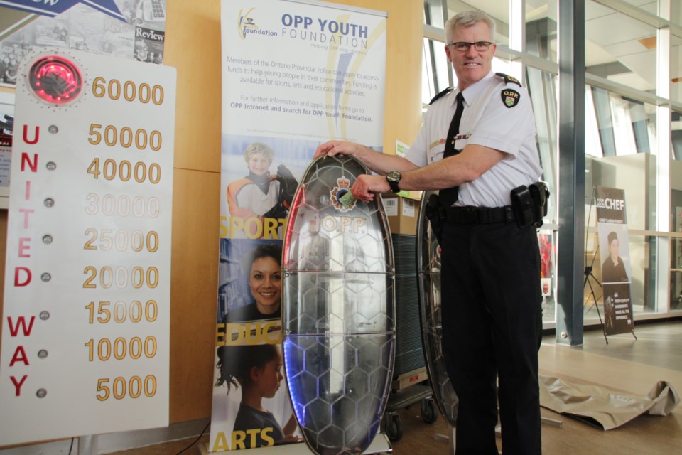 Vince Hawkes, commissioner OPP, kicked off the program by dropping a donation in one of the collection kiosks. Photo by Mehreen Shahid for OrilliaMatters