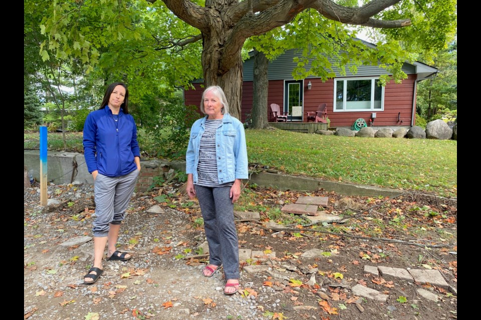Melissa McKee, left, and Kathy Hunt are shown in front of Hunt's house on Driftwood Road. They are standing on a property for which an eight-storey condo building has been proposed.
