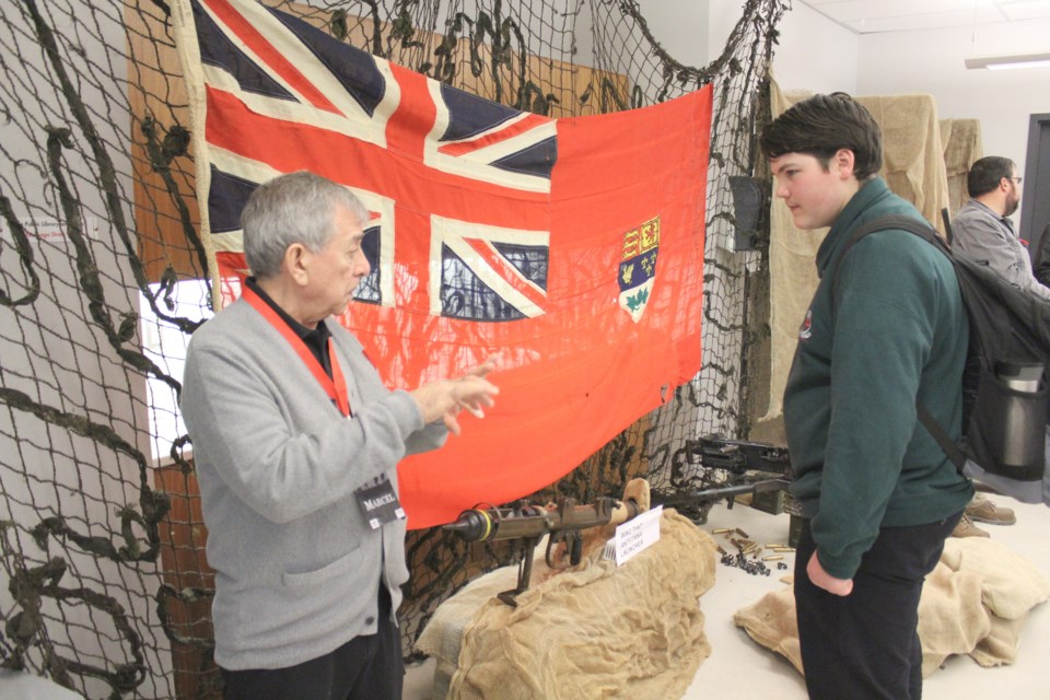Marcel Rousseau speaks with Logan Hill, a Patrick Fogarty Catholic Secondary School student, at the Orillia Public Library's interactive Remembrance Day exhibit Thursday. Nathan Taylor/OrilliaMatters