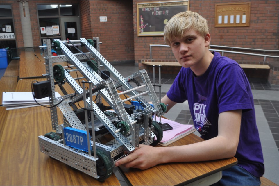 Elliot Gagnon of Barrie is pictured with his team’s robot during a competition at Patrick Fogarty Catholic Secondary School. Andrew Philips/Orillia Matters
