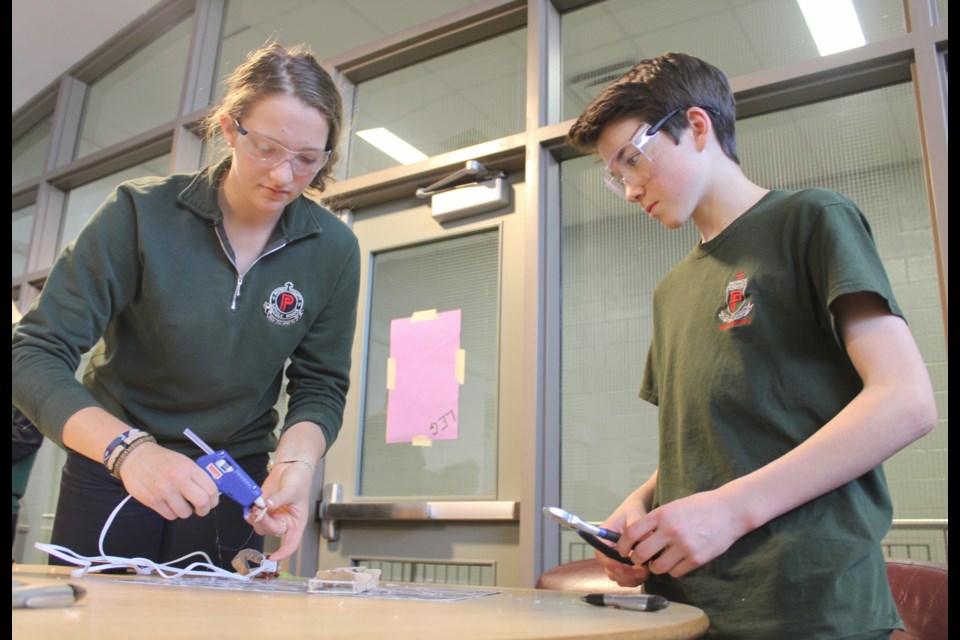 Olivia Klingspohn and Avery Warboys work on their Popsicle stick bridge Friday during the STEM industry tour's stop at Patrick Fogarty Catholic Secondary School. Nathan Taylor/OrilliaMatters