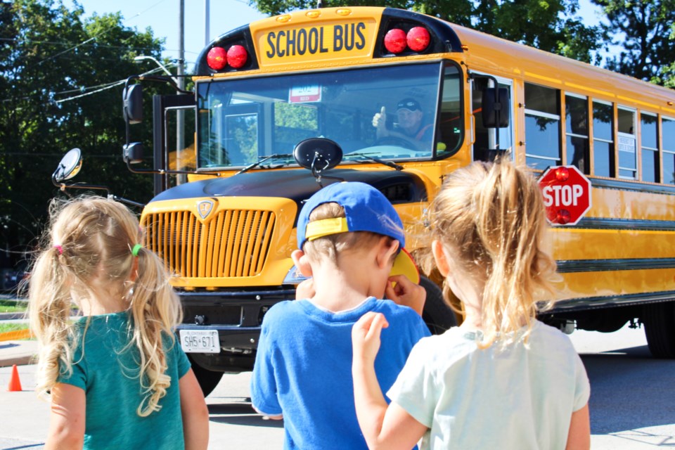 A driver gives kids the sign that it's safe to cross in front of the bus Wednesday during the Simcoe County Transportation Consortium's First Rider program at Monsignor Lee Catholic School in Orillia. Nathan Taylor/OrilliaMatters