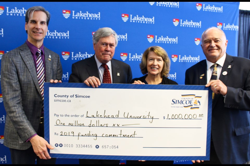 The County of Simcoe provided Lakehead Orillia with a cheque for $1 million on Tuesday. On hand for the presentation were, from left, Dean Jobin-Bevans, principal of Lakehead Orillia, Ross Murray, president of Lakehead's board of governors, Moira McPherson, Lakehead's president and vice-chancellor, and Simcoe County Warden George Cornell. Nathan Taylor/OrilliaMatters