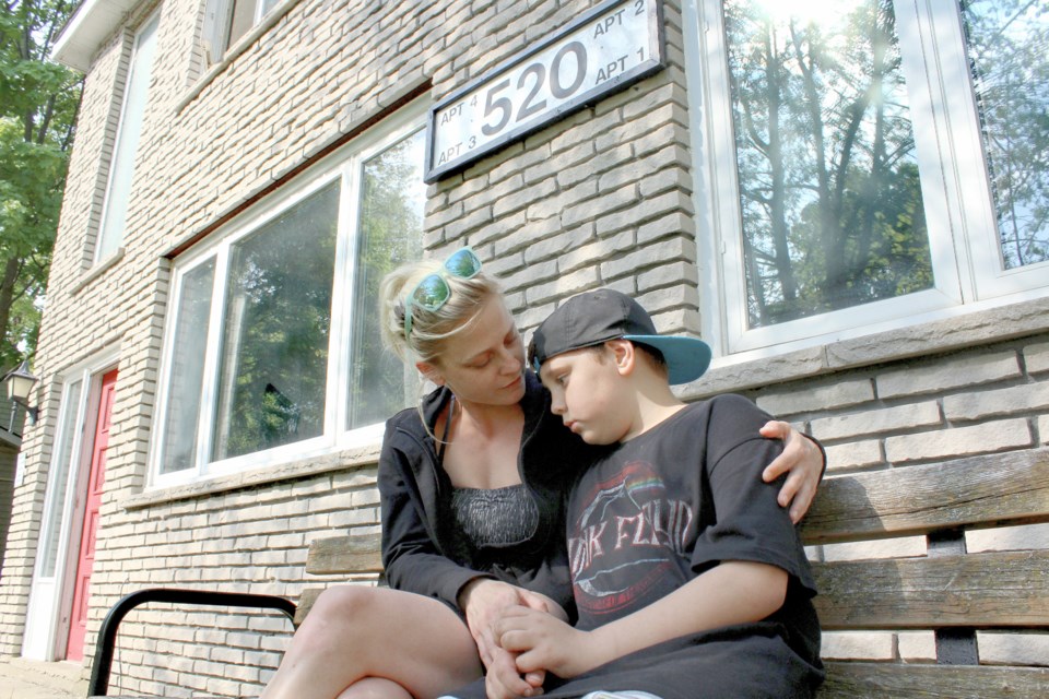 Taya Fielding consoles her son, Preston, outside of their apartment at 520 High St. on Friday. The family lost everything in a fire May 15. Nathan Taylor/OrilliaMatters