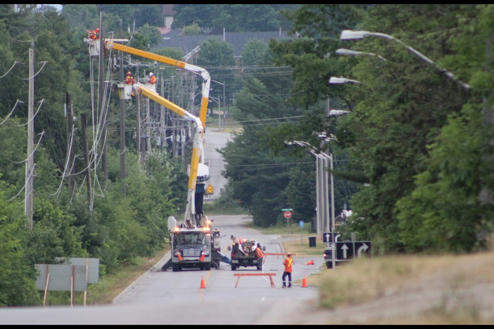 An Orillia Power crew works to restore hydro after a pole caught fire and broke Monday afternoon on Murphy Road, near Walmart. Nathan Taylor/OrilliaMatters